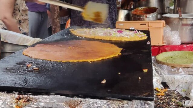 Footage of a person making stuffed besan chilla or cheela using flour