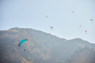 The sport of paragliding. Parachuting over high mountains. Beautiful natural landscape.