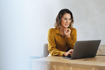 Business woman using a laptop for an online meeting in her office