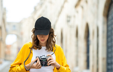 Girl with a vintage camera on an old street.