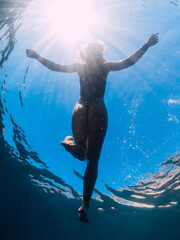 Sexy woman relaxing on sea surface, underwater view.