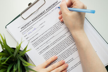 Property management agreement, hand fills out a document, insurance paperwork, agency, finance...