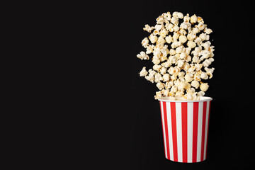 Popcorn bucket, salted treat, classic entertainment snack, tasty cinema, black background, copy space