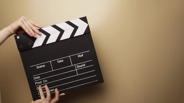 hands with movie clapperboard, on set of a Hollywood production, director coordinating actors, cinematic scene in progress