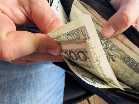 Man hand holding polish money 100 200 zl pln zloty. Business or financial background