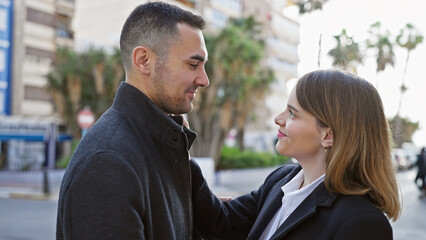 Affectionate couple enjoying a romantic moment together on a vibrant city street.