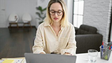 Young blonde woman business worker using laptop working at the office