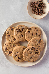 Chocolate chip cookies on a plate with a gray background. 