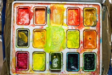 watercolor paints in the warm color of flatlay