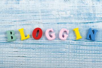 BLOGGING word on wooden background composed from colorful abc alphabet block wooden letters, copy...