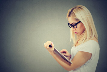 Portrait of a serious blond woman using tablet computer 