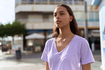 Young african american woman looking to the side with serious expression at street