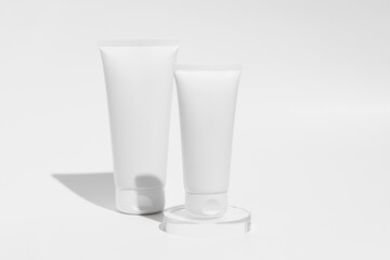 Two white mockup jars of body or face cream on white isolated background. Concept of products for skin care, beauty and aesthetics