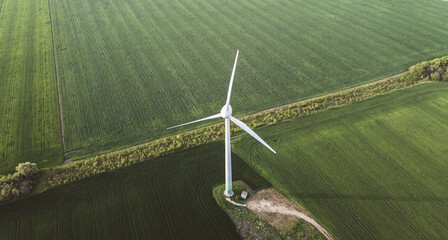 carbon neutral electricity power. Aerial view of green meadows with renewable energy wind turbine