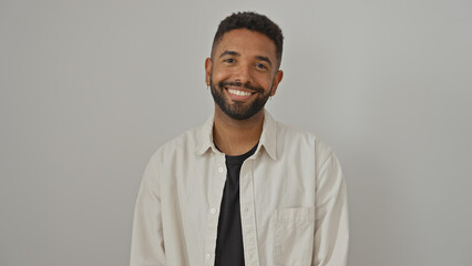 A smiling young black man with a beard posing casually against a white background, exuding...