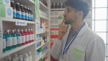 Thoughtful man contemplating products in a well-organized indoor pharmacy