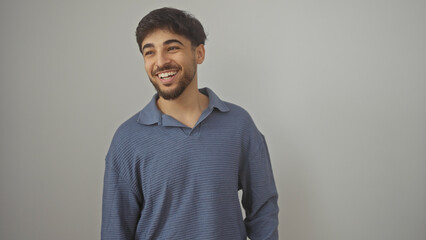 Handsome arab man with beard smiling against a white background wearing a casual shirt