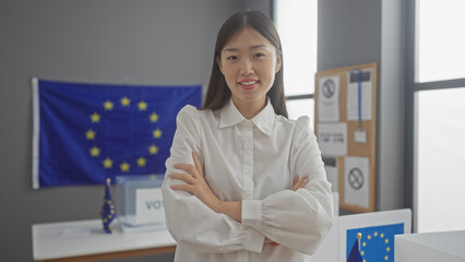 Confident asian woman with crossed arms standing in a european electoral college room with eu flags