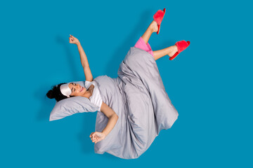 Full body portrait of pretty young woman stretch levitate bed wear pajama isolated on blue color...