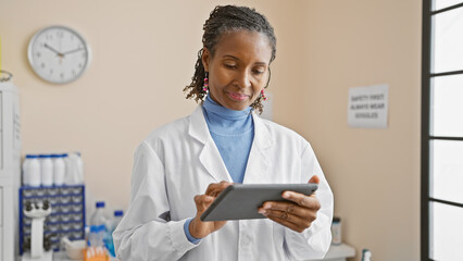 African american woman doctor using tablet in clinic