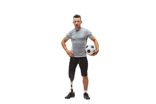 Athletic man with prosthetic leg confidently holding soccer ball, showing determination and fitness isolated on transparent background. Concept of inclusive sport, motivation, heath care, endurance