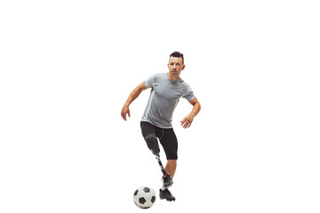 Innovative athlete. Fit soccer player with high-tech prosthetic leg in motion with football ball, training isolated on transparent background. Inclusive sport, motivation, heathcare, endurance concept