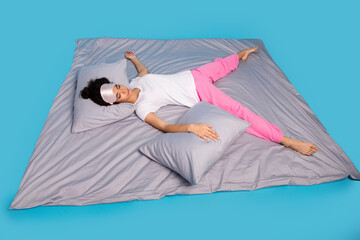Full body portrait of pretty young woman lying comfy bed wear pajama isolated on blue color...