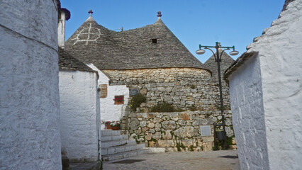 Charming view of traditional white trulli houses in the historic town of alberobello, puglia,...