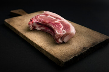 raw meat on wooden board and black background
