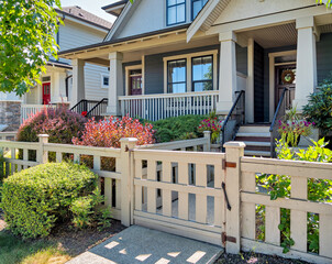 The porch and entrance door of nice residential house with wooden gate in front