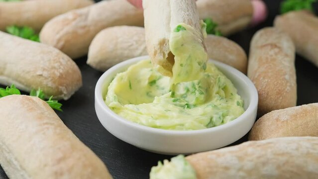 Dipping ciabatta bread sticks in creamy garlic butter dip.