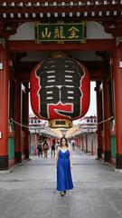 Beautiful hispanic woman donning glasses, flashing a cheerful smile at the senso-ji temple,...