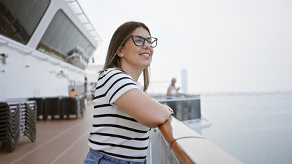 Smiling woman enjoying ocean view on the deck of a cruise ship, embodying travel, leisure, and vacation ambiance.