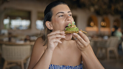 Young hispanic woman eating fusion food at the restaurant