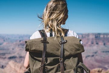 Back view of female traveler with backpack enjoying active lifestyle exploring nature of USA...