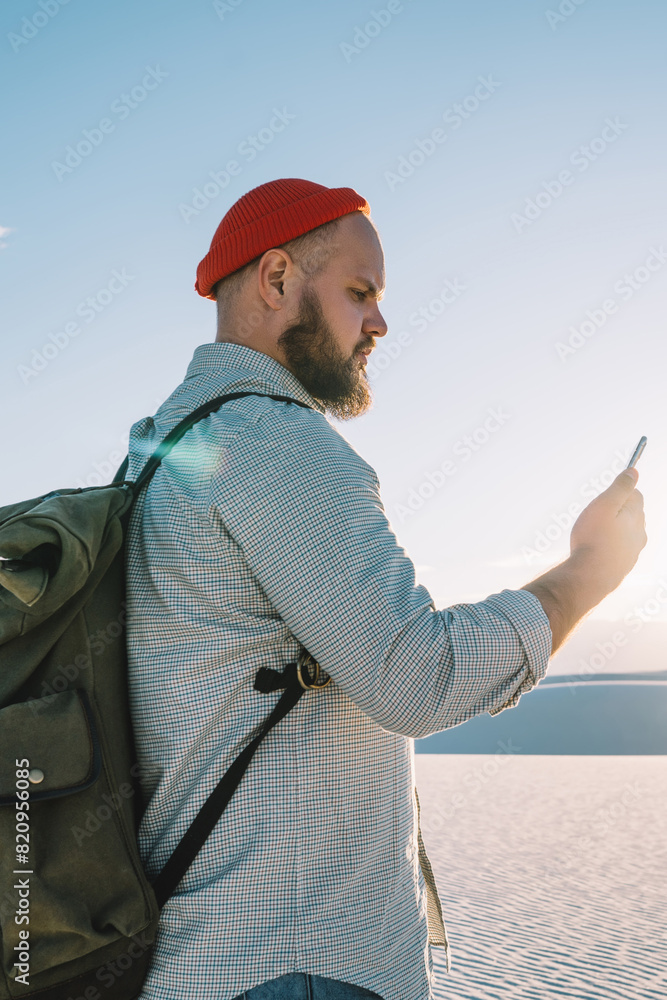 Poster young hipster guy checking application notification navigating via smartphone and good mobile data c