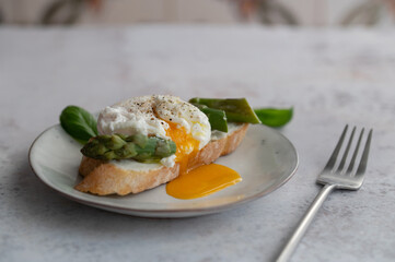 Toast bruschetta with grilled asparagus, poached egg and fresh cream cheese. Sourdough bread with vegetables and egg. Food photography. Healthy breakfast, brunch. Summer food.