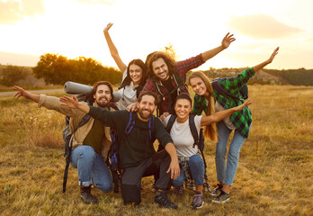Cheerful friends having fun and enjoying hiking or trekking weekend excursion together. Group...