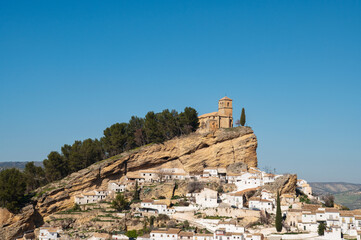 Old town Montefrio. The ruins of a Moorish castle on a rock and white houses under cloudless sky. Pueblos blancos, Andalusia, Spain. Spanish white villages