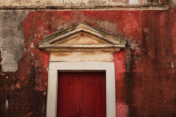 traditional greek architecture, wooden entrance door, old painted walls, rustic texture, abandoned property need maintenance