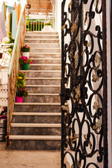 typical mediterranean house atrium entrance, amazing metal garden door, stairs with pot flowers,...