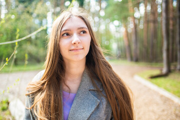 Portrait of a beautiful young girl with long hair in the forest	