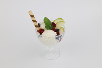 Ice cream with fresh blueberries, mint and wafer stick in glass vase isolated on white background