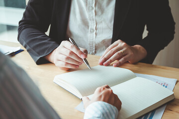 person signing an important business document, showcasing cooperation and legal consent,...