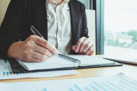 A student intensely studying and writing in a notebook, preparing for an upcoming exam in a university classroom setting, highlighting the importance of education and academic success