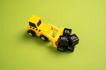 A bulldozer drags cubes of CO2. Greenhouse gas emissions from industry. New rules and directives,...