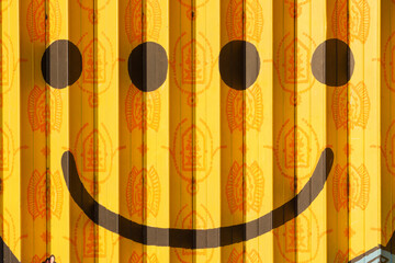 Yellow rolling door with smile emoticon mural paint