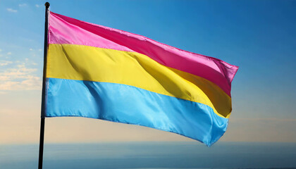 Obraz premium pansexual flag flutters against blue sky, lgbtq pride month, pan