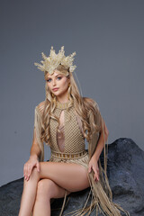 Beautiful bvlond lady in Greek clothes, 
a girl in a knitted macrame beige dress, bodysuit, gold...