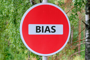 Concept of facts and biases. A word BIAS on the road sign in front of the forest